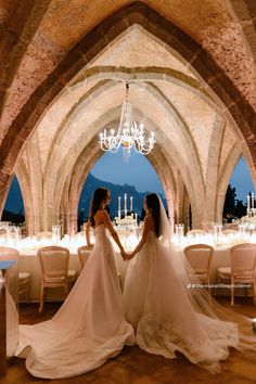 two brides standing in an archway holding hands