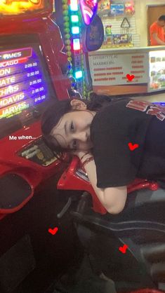 a woman laying on top of a red motorcycle in front of a slot machine at a casino