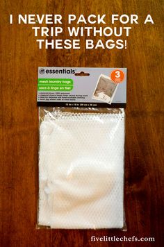 a pack of white bags sitting on top of a wooden table next to an envelope