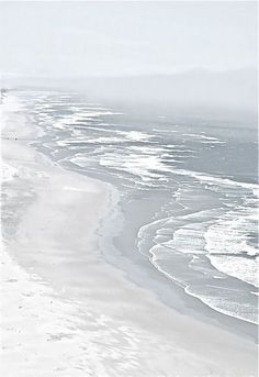 an aerial view of the beach and ocean with waves coming in from the water,