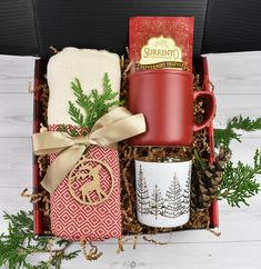 a christmas gift box with coffee mug, tea towel and other holiday items in it