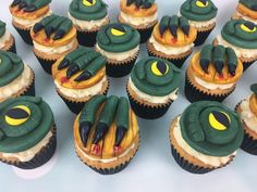 cupcakes with green and yellow frosting decorated like eyes, mouths and hands