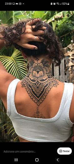 the back of a woman's neck with tattoos on it