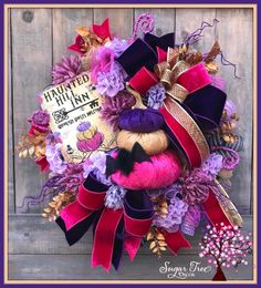 the wreath is decorated with purple and red ribbons