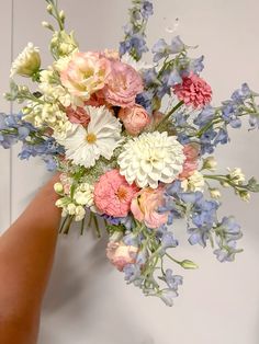 a person holding a bouquet of flowers in their hand