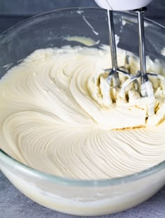 a mixer mixing cream in a glass bowl