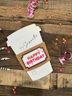 a coffee cup with the words happy birthday on it next to confetti and streamers