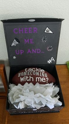 a football in a black box with writing on it and tissue paper around the edges