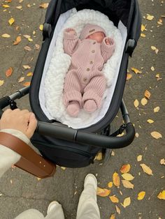 a baby in a stroller being held by someone