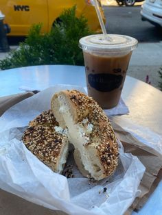 a bagel and coffee on a table outside