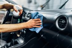 a man cleaning the inside of a car with a microfibrel and cloth