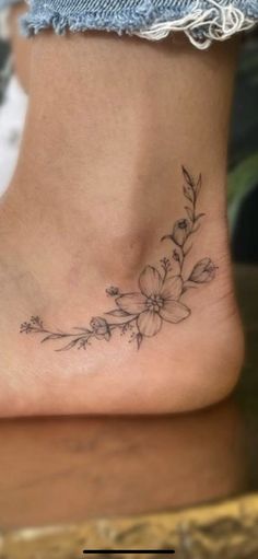 a woman's foot with a flower tattoo on the side of her body and bottom part