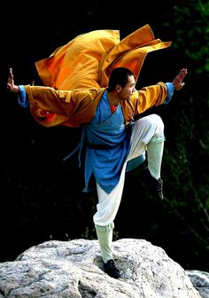 a man is doing an acrobatic move on top of a rock