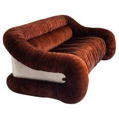 a couch that is shaped like an animal's tail and has a pillow on it