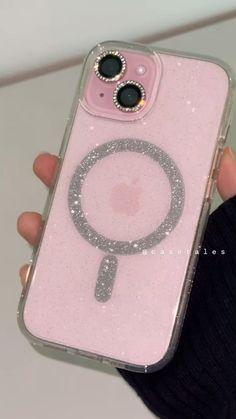 a person holding a pink phone case with a magnifying glass on the back