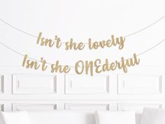 a living room with white couches and gold foil letters on the wall that says, isn't she lovely in the onederfy