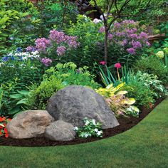 a garden filled with lots of different types of flowers and rocks in the middle of it