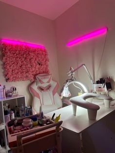 a room with pink lighting and various items on the table