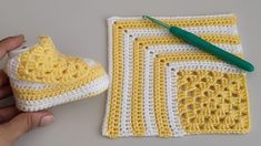 a crocheted yellow and white dishcloth next to a pair of green scissors