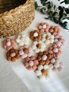 small crochet flowers are on a table next to a basket