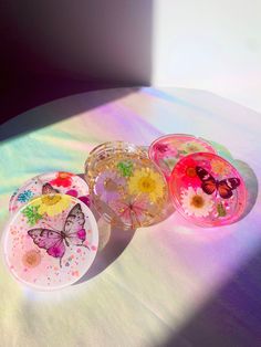 three glass plates sitting on top of a table next to each other with butterflies painted on them