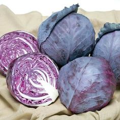 some purple cabbages are sitting on a cloth