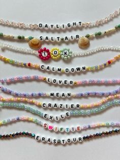 several beads with words written on them are arranged in the shape of letters that spell out their names