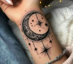 a woman's arm with a crescent and stars tattoo on it