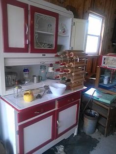 an old fashioned kitchen with red and white cabinets in the process of remodeling