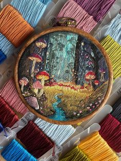 embroidery kit with mushrooms and stream in the woods surrounded by spools of thread