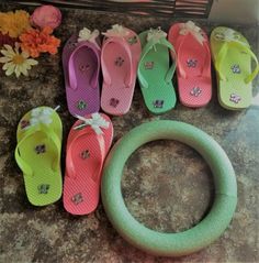 several pairs of flip flops sitting on top of a counter next to a wreath