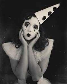 a woman wearing a party hat with her hands on her face