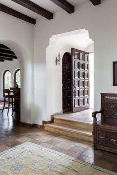 a living room filled with furniture next to a dining room table and two doorways