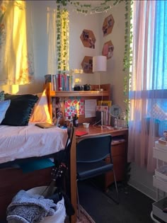 a bedroom with a bed, desk and chair next to a window covered in curtains