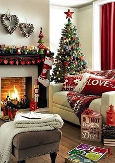 a living room decorated for christmas with red and green decorations on the fireplace mantel