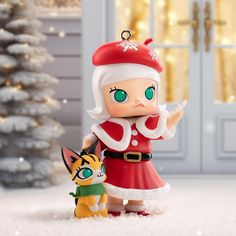 a small figurine is standing next to a cat in front of a christmas tree