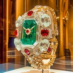 This striking second piece in the Dazzle Time collection radiates pure extravagance with a bold combination of emeralds, rubies, and diamonds, intricately crafted to resemble an ultra-luxurious watch. The oversized emerald centerpiece, surrounded by radiant diamonds and ruby accents, transforms the traditional idea of a timepiece into a dazzling work of art. The gold details and intricate settings evoke a sense of timeless grandeur, making this digital creation a stunning celebration of opulence. Welcome to my high-concept art for the wall, shelf, Digital Picture frame, or computer desktop wallpaper.  Art Description: Imperial Jewel commands attention with its resplendent emerald face, reminiscent of the grand treasures of empires past. The immense central emerald is framed by flawless dia Luxury Jeweled Diamond Jewelry, Luxury Diamond Watch With 17 Jewels As Gift, Elegant Green Diamond Watch For Formal Occasions, Luxury Jeweled Emerald Jewelry, Luxury Green Diamond Watch For Formal Occasions, Green Luxury Diamond Watch For Formal Occasions, Elegant Green Watch As A Gift, Elegant Green Watch For Gift, Watch Concept Art