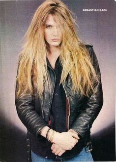 a woman with long blonde hair wearing a leather jacket