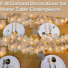 the table is set with white plates and silver utensils for fall garland decorations