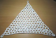 a crocheted triangle sitting on top of a wooden table