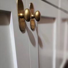 a close up of a door handle on a white door with gold knobs and handles