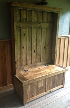 a wooden bench sitting on top of a hard wood floor next to a wall and window