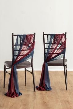 two chairs with red, blue and grey fabric draped over them on top of hard wood flooring