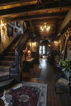 the inside of a house with stairs and chandeliers on either side of it