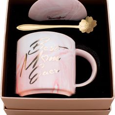 a pink and white coffee mug with a gold spoon in its gift box that says best mom ever