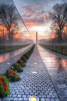 the vietnam veterans memorial at sunset with an american flag and wreaths in front of it