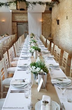 a long table is set up with place settings and silverware for an elegant dinner