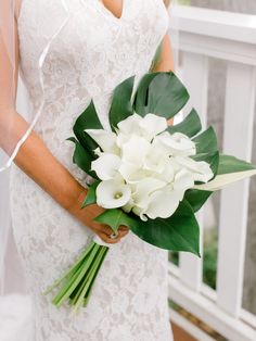 a bride holding a bouquet of white flowers