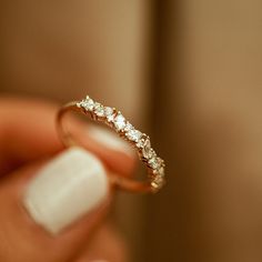 a close up of a person holding a ring with diamonds on it's side