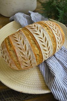 a loaf of bread sitting on top of a plate next to a blue and white towel